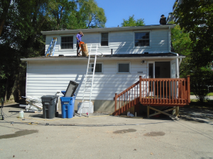 pest control technician working on the roof of a house